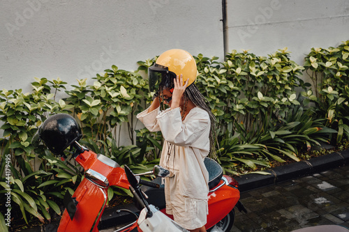 Woman with helmet and scooter outside in bali