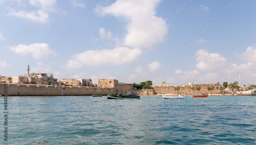 View from the boat to the Mediterranean Sea, the fortress wall and buildings in the old city of Acre in northern Israel