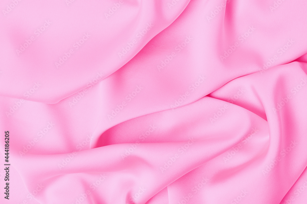 Obraz premium Folds on pink silk fabric close-up, texture and background.