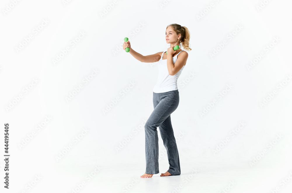 sportive woman holding green dumbbells in hands muscles workout fitness