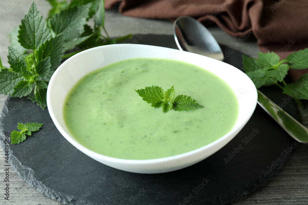 Concept of healthy food with nettle soup on gray textured table Concept of healthy food with nettle soup on gray textured table