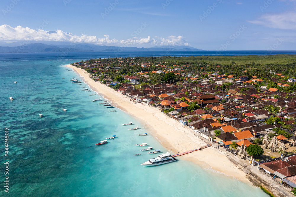 Stunning aerial view of the Nusa Lembongan with a speed boat anchored in the Jungut Batu village and Agung volcano in Bali, Indonesia