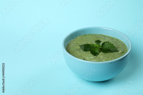 Plate of fresh nettle soup on blue background