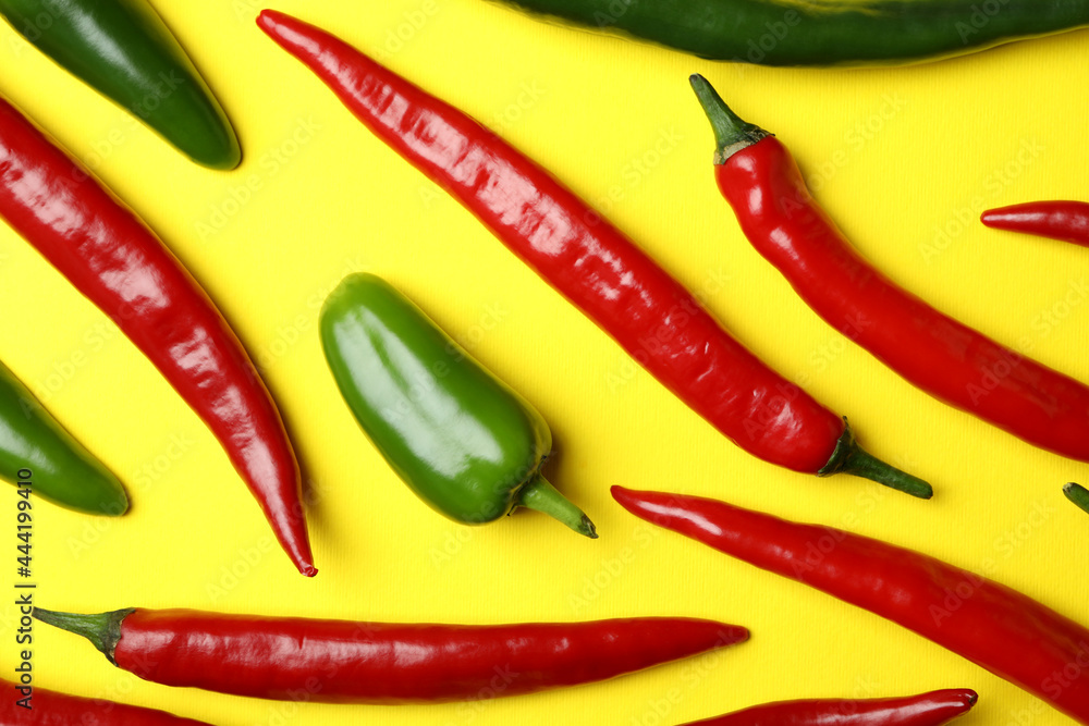 Red and green hot peppers on yellow background
