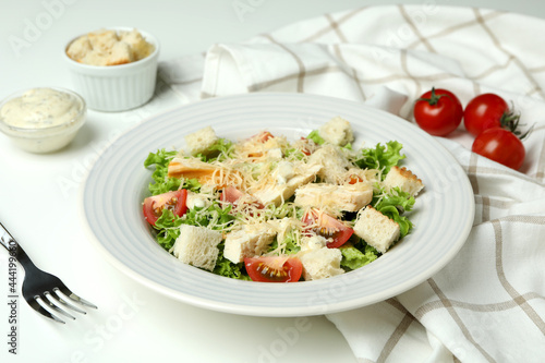 Concept of tasty eating with Caesar salad on white table