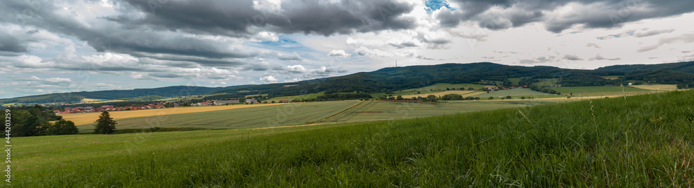 Panoramic view to summer Czech landscape with small vilage Chlum and hill Klet at dramatic cloudy sky