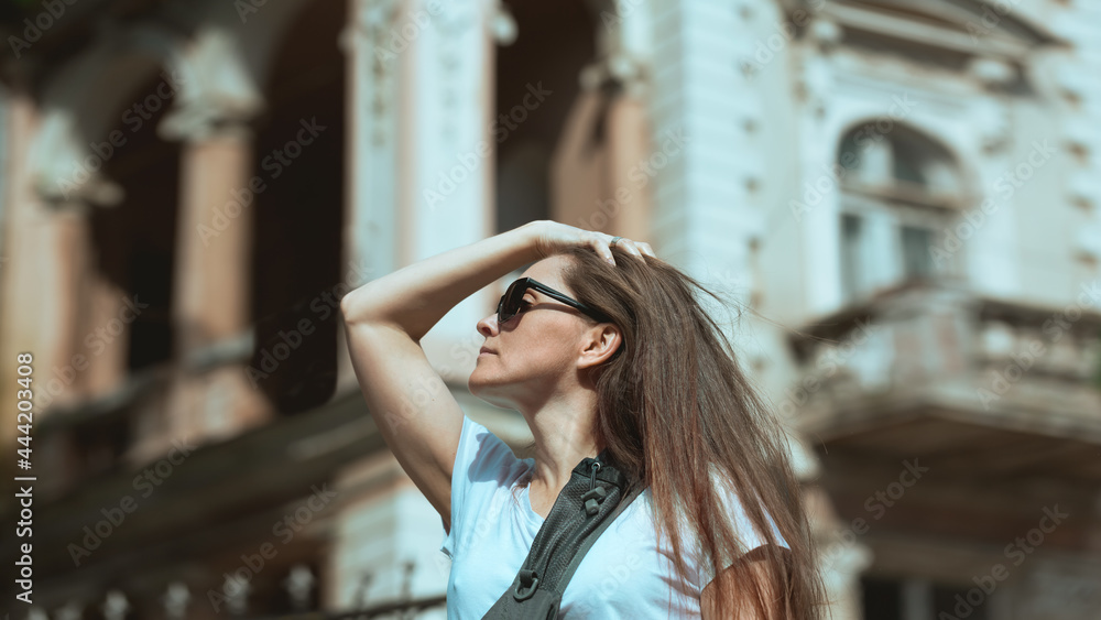 Fototapeta premium Portrait of a young beautiful woman on a trip to the ancient cities of Europe