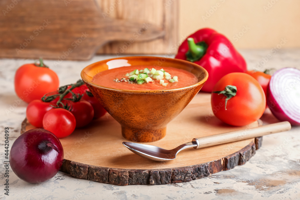 Bowl with tasty gazpacho and vegetables on color background Bowl with tasty gazpacho and vegetables on color background