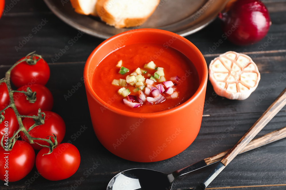 Bowl with tasty gazpacho and vegetables on dark wooden background, closeup Bowl with tasty gazpacho and vegetables on dark wooden background, closeup