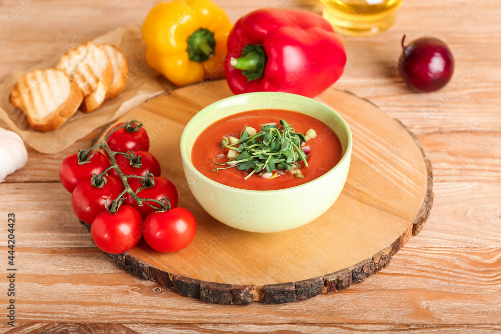 Bowl with tasty gazpacho and vegetables on wooden background Bowl with tasty gazpacho and vegetables on wooden background