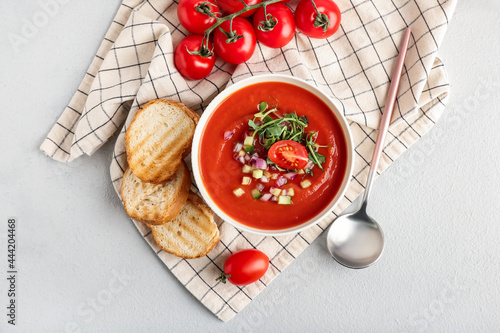 фотографія Bowl with tasty gazpacho and bread slices on light background