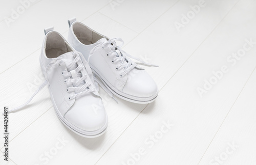 White leather sneakers with laces  on white background photo