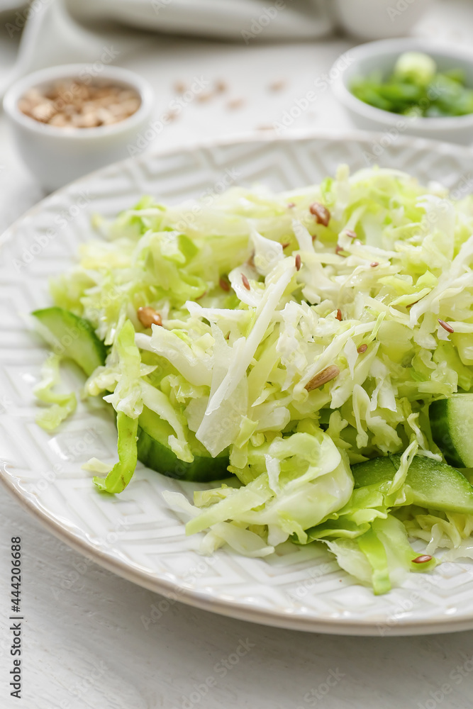Plate with tasty cabbage salad on light wooden table, closeup Plate with tasty cabbage salad on light wooden table, closeup