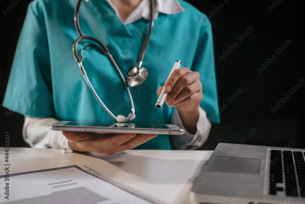 Doctor working on tablet and laptop computer on clipboard in the desk, electronics medical record system EMRs concept. Doctor working on tablet and laptop computer on clipboard in the desk, electronics medical record system EMRs concept.