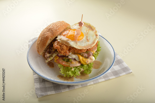 chef handmade giant deep fried crispy chicken with fried egg and vegetables cheesy burger in japanese sesame sauce western fast food halal menu