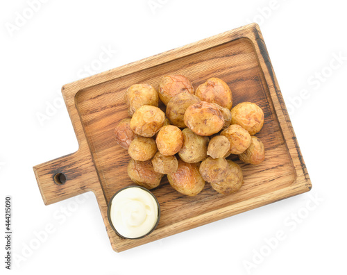 Wooden board with tasty baked potato and sauce on white background