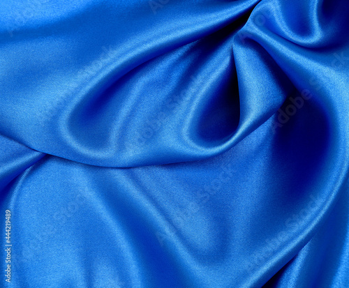 Smooth elegant blue silk or satin luxury cloth texture as abstract background. Luxurious Christmas background or New Year background design