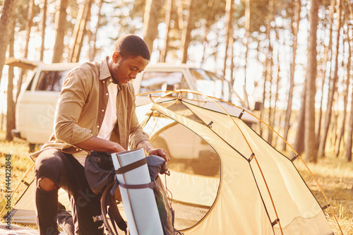 Man is traveling alone in the forest at daytime at summer