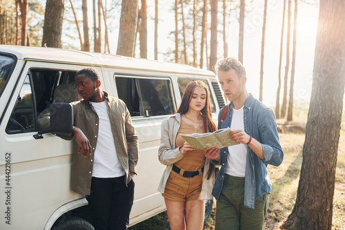 Group of young people is traveling together in the forest at daytime