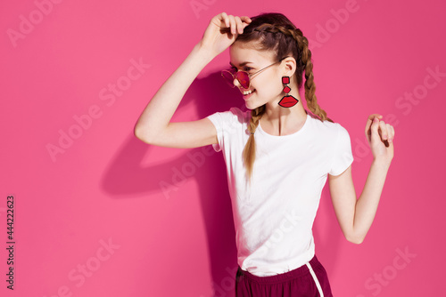 pretty woman with pigtails wearing sunglasses pink background street style