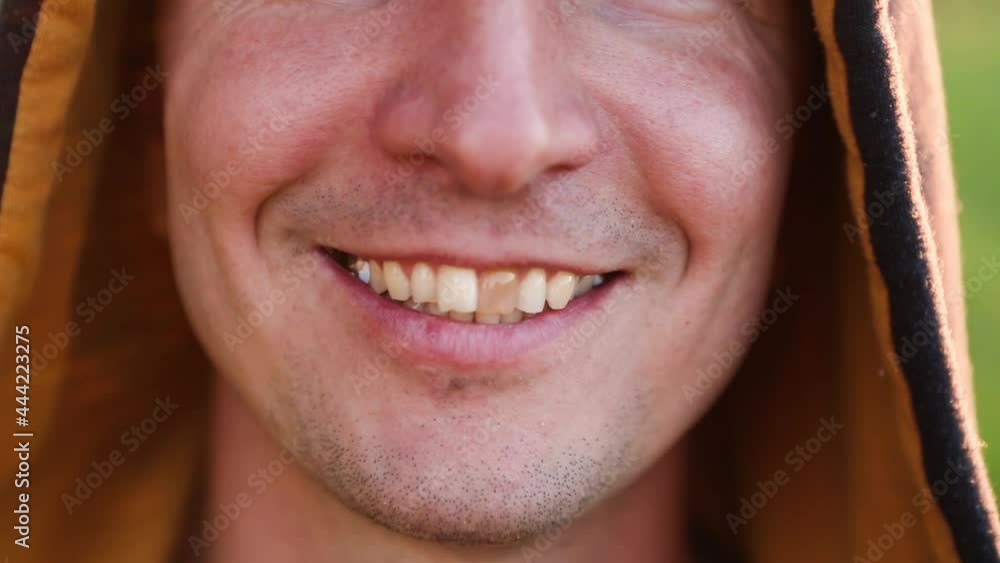 Yellow damaged tooth of smiling Caucasian man in the hood close-up. Focus on the teeth, open mouth. Dental problems, dead teeth, enamel whitening, aesthetic restoration. Natural enamel, body positive Yellow damaged tooth of smiling Caucasian man in the hood close-up. Focus on the teeth, open mouth. Dental problems, dead teeth, enamel whitening, aesthetic restoration. Natural enamel, body positive