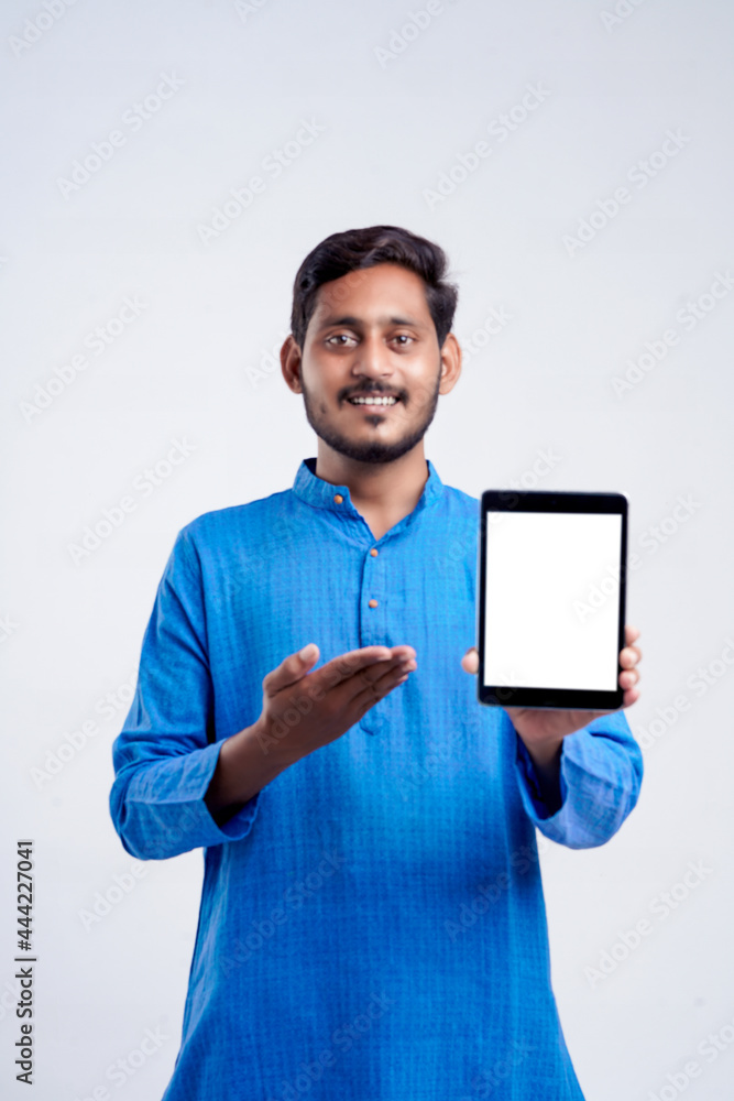 Young indian man showing tablet over white background. Young indian man showing tablet over white background.