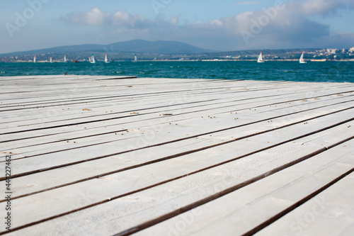 Light wooden board on the bridge in front of the sea close-up