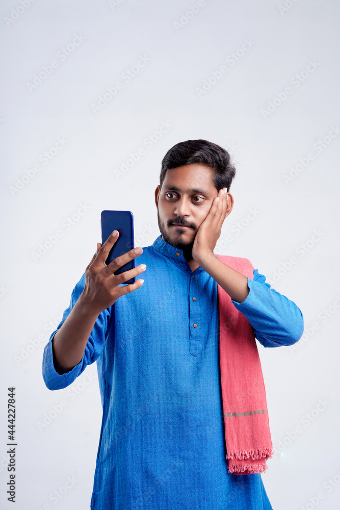 Young indian farmer using smartphone on white background. Young indian farmer using smartphone on white background.