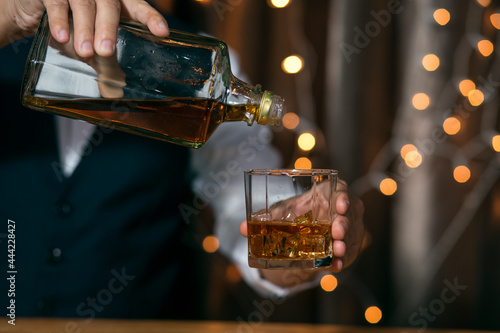 Barman pouring whiskey whiskey glass beautiful night celebrate whiskey on a friendly party in restaurant