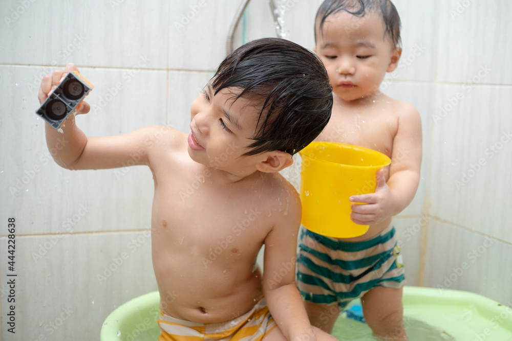 two little boys take a bath and play together two little boys take a bath and play together