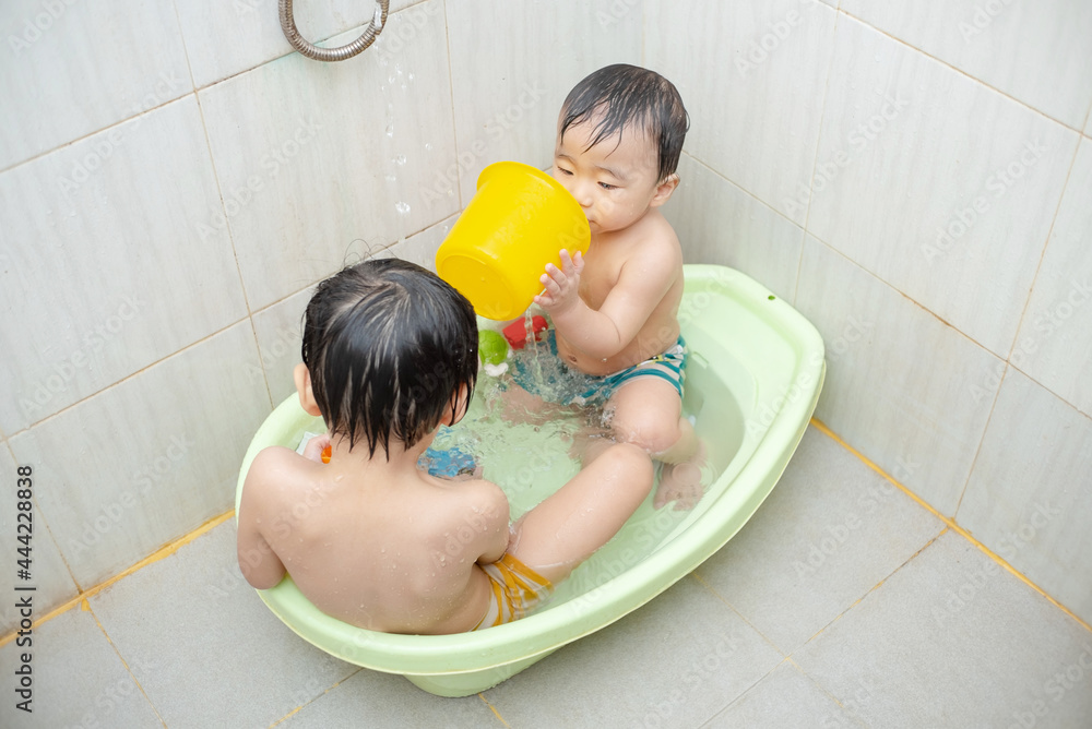 two little boys take a bath and play together two little boys take a bath and play together