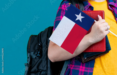 Young girl with school stuff holds in hand Texas flag close up