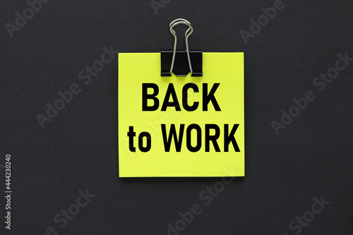 Back to Work. text on a black background, on a bright yellow sticker