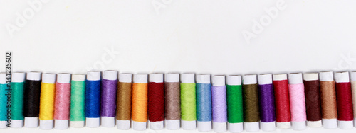Set of multi-colored skeins of thread on a white background with place for text. Sewing or tailor shop, for advertising