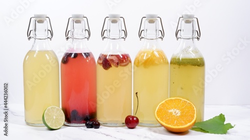 5 flavored Kombucha swing top bottles in front of light background