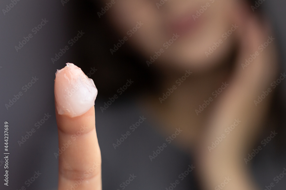 Closeup of a woman applying petroleum jelly to her face. Concept of slugging and skin care for dry, dehydrated skin. Closeup of a woman applying petroleum jelly to her face. Concept of slugging and skin care for dry, dehydrated skin.