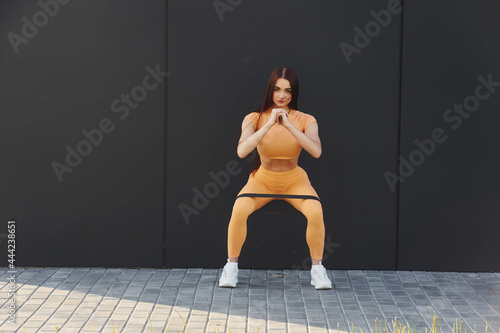 Stretching exercises. Young woman in sportswear have fitness session outdoors
