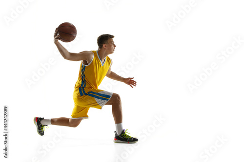 Side view. One young man  basketball player with a ball training isolated on white studio background. Advertising concept. Caucasian athlete in action.