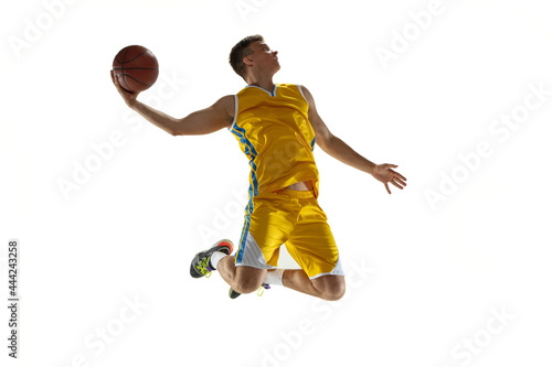 In action. One young man, basketball player with a ball training isolated on white studio background. Advertising concept. Caucasian athlete jumping with ball. © master1305
