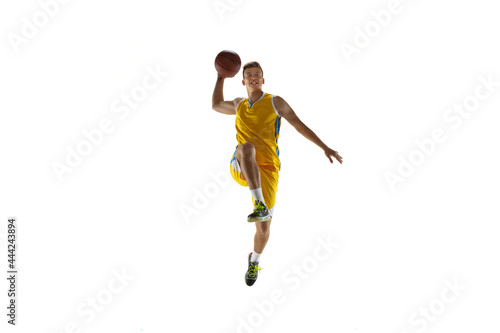 One young man, basketball player with a ball training isolated on white studio background. Advertising concept. Fit Caucasian athlete jumping with ball.