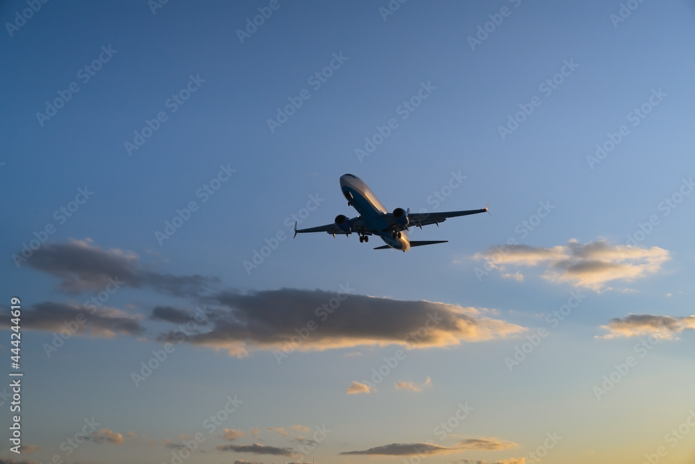 The plane comes in for landing at sunset The plane comes in for landing at sunset