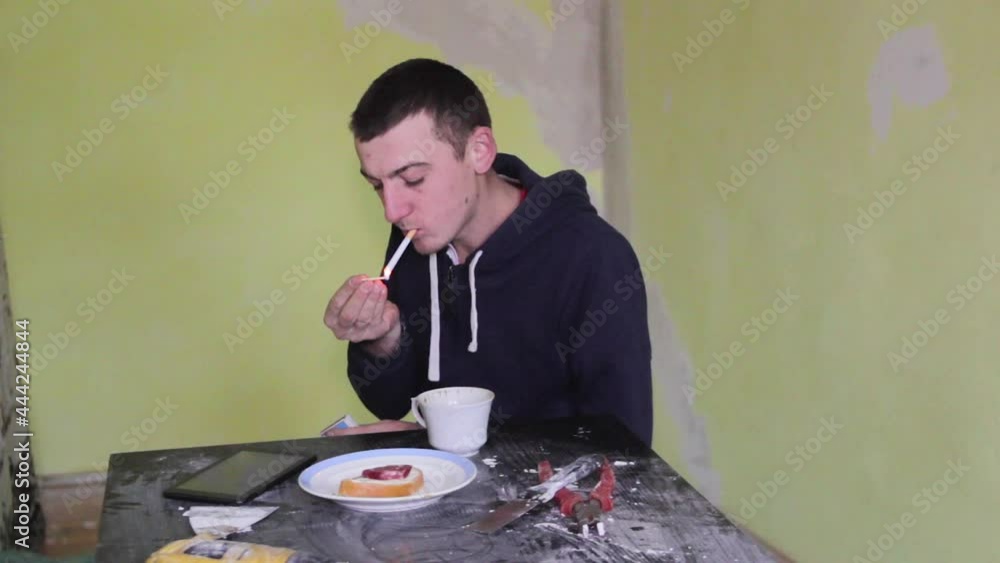 smoke break in the builder,repairs in the room, the man smokes cigarettes and drinks coffee smoke break in the builder,repairs in the room, the man smokes cigarettes and drinks coffee