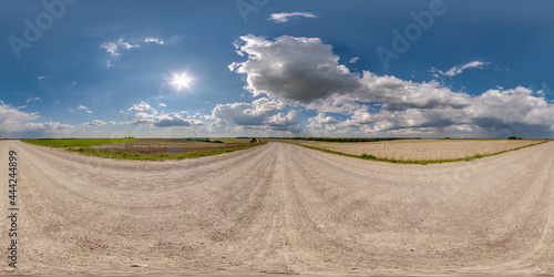 Full spherical seamless hdri panorama 360 degrees angle view on no traffic yellow sand gravel road among fields with sunny day and awesome clouds sky in equirectangular projection, VR AR content