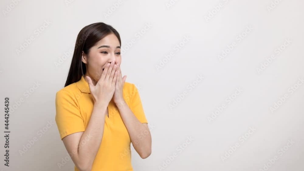 Excited asian woman shout out loud wow with hands looking on blank space isolated background. Happy shocked face female wow promotion concept. Joyful teenage girl in yellow shirt standing in room. Excited asian woman shout out loud wow with hands looking on blank space isolated background. Happy shocked face female wow promotion concept. Joyful teenage girl in yellow shirt standing in room.