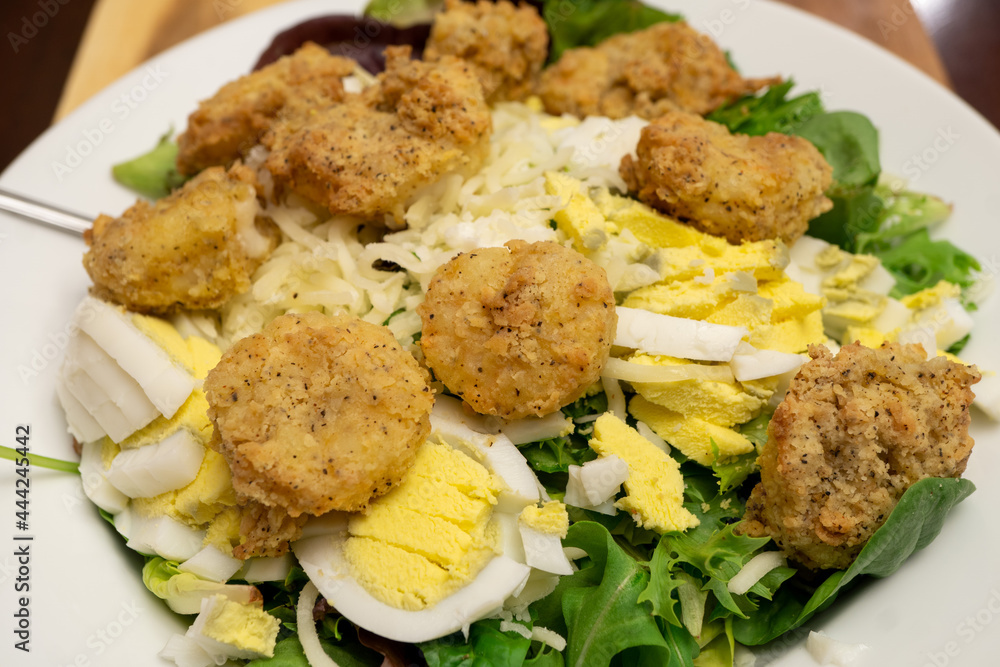 Fried shrimp, made using an air fryer, atop a bed of spinach, mixed greens, hard boiled eggs, and Mozzarella cheese Fried shrimp, made using an air fryer, atop a bed of spinach, mixed greens, hard boiled eggs, and Mozzarella cheese