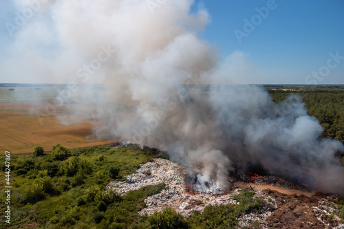 Wild fire at a trash dump. White and gray smoke from burning rubbish on the town dump