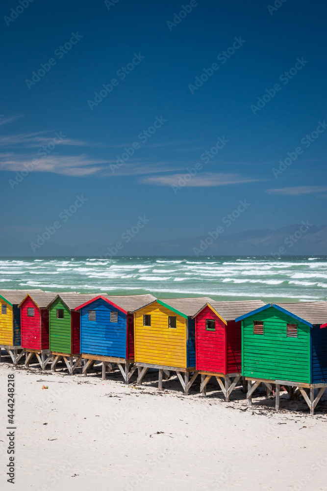 Fototapeta premium Famous colorful beach houses in Muizenberg near Cape Town, South Africa with Hottentots Holland mountains in the background.