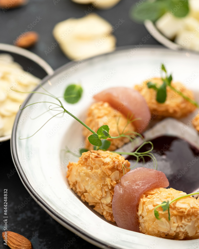 Exotic food. Appetizer in almond petals, garnished with microgreens of peas. Soft focus. Close-up shot. Vertical format. Exotic food. Appetizer in almond petals, garnished with microgreens of peas. Soft focus. Close-up shot. Vertical format.