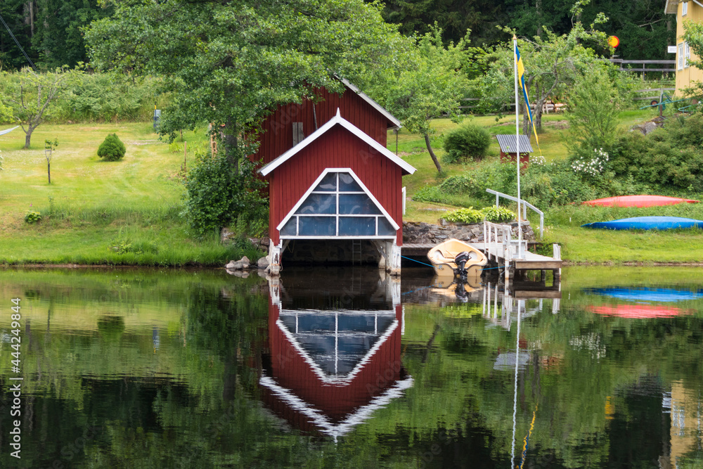 Fototapeta premium Haverud, Sweden A house is reflected in the water along the Dalsland Canal in western central Sweden on a bridge.