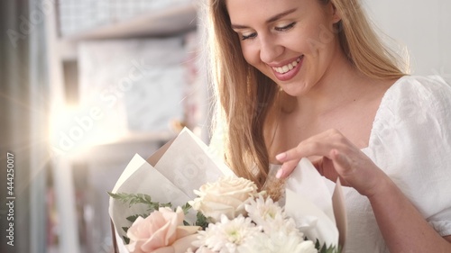 Photos Young woman appreciating flower bouquet fragrance
